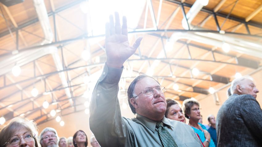 A man raises his hand in praise during the National Anthem before the Iowa Faith and Freedom Coalition annual banquet and presidential forum  Saturday Sept. 19, 2015 in Des Moines, Iowa.
(Taylor Glascock for CNN)