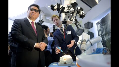 Xi wears 3-D glasses as he views robotic equipment October 21 at Imperial College London.