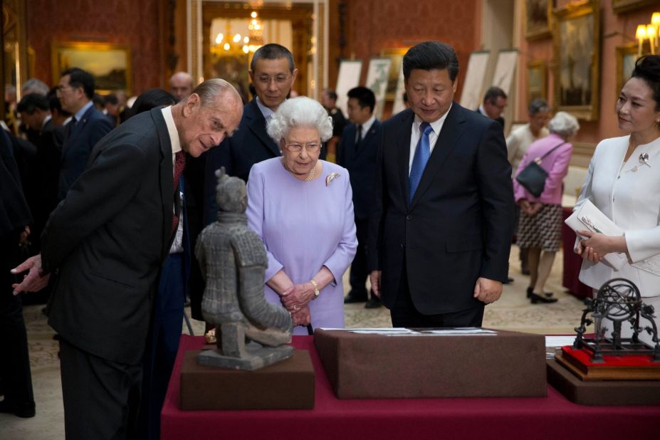 Prince Philip, Queen Elizabeth II, Xi and Peng view a display of Chinese items from the Royal Collection at Buckingham Palace.