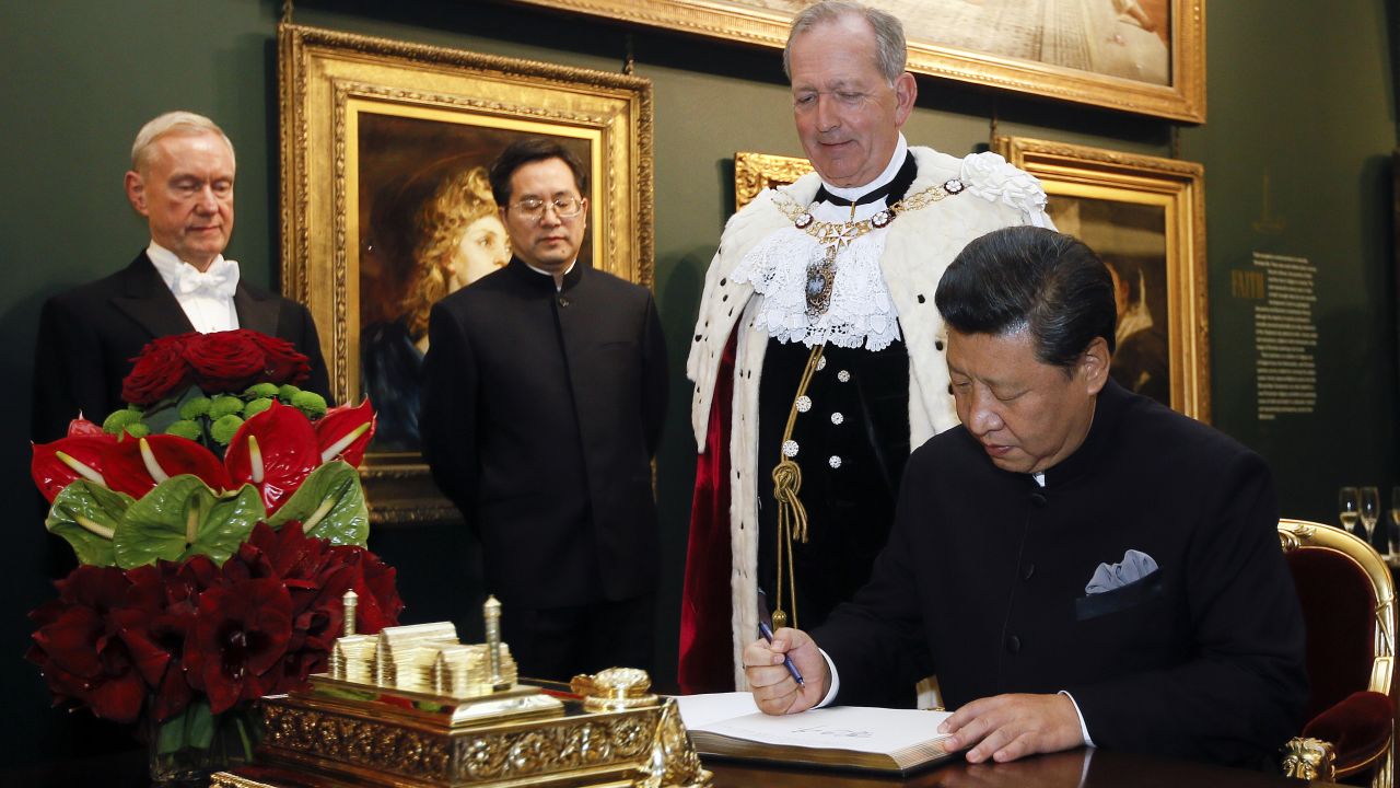 Xi signs the distinguished visitors book before a banquet at the Guildhall in London on Wednesday, October 21.