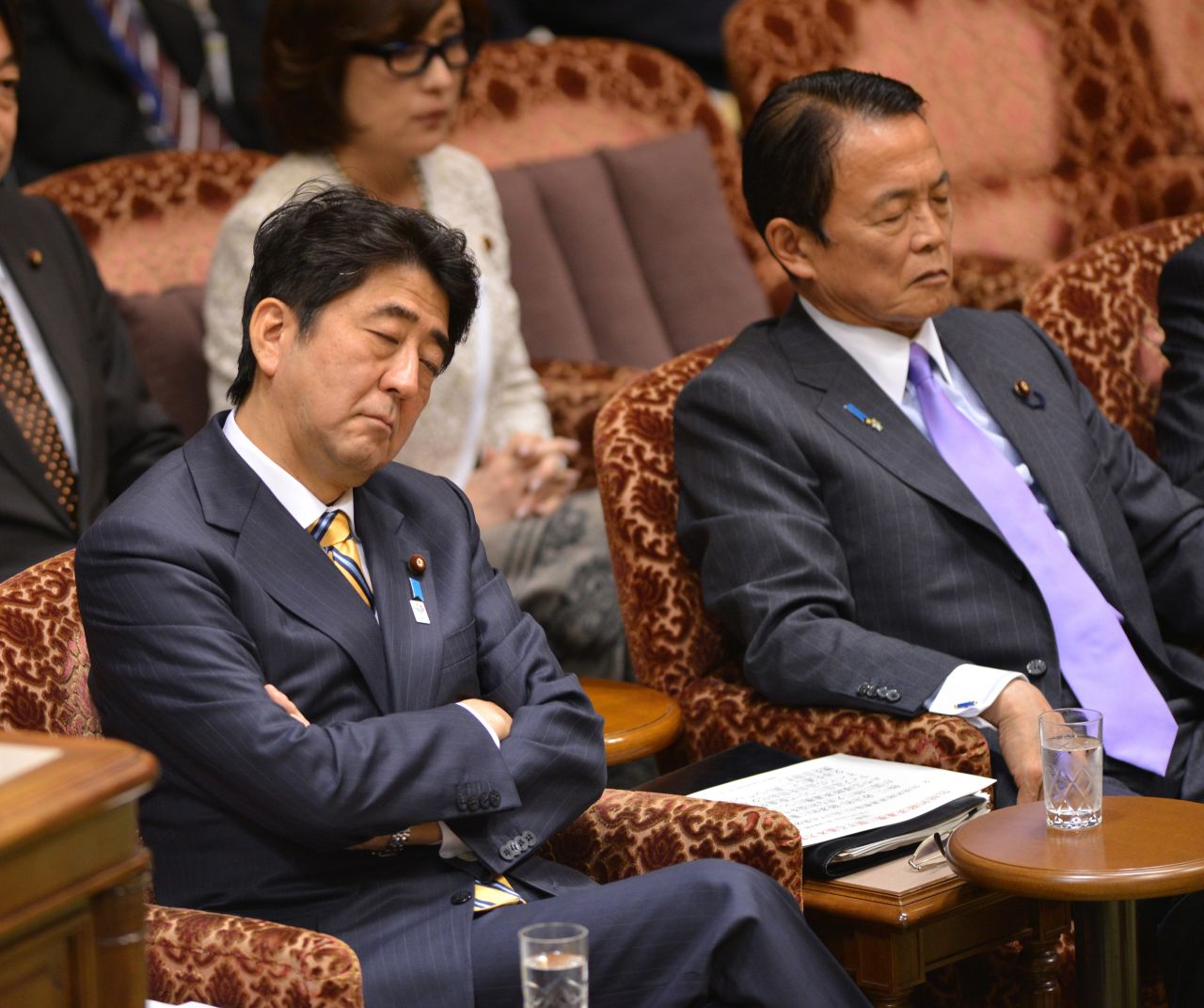 Japanese Prime Minister Shinzo Abe (L) and Finance Minister Taro Aso "listen" to a question from an opposition lawmaker during a budget session at the National Diet in Tokyo in February 2013.