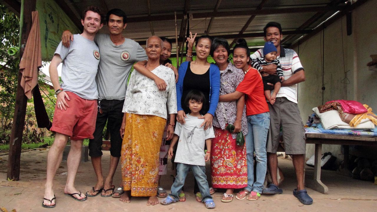Boon, left, stands next to Kry, the Cambodian man whom he credits with the idea of producing bags recycled from locally available materials. With them is Kry's family.