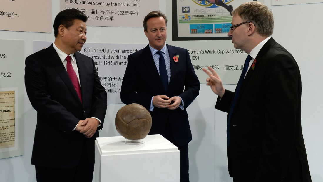 Xi and Cameron view the ball used in the first World Cup final during a visit to the City Football Academy in Manchester on October 23.