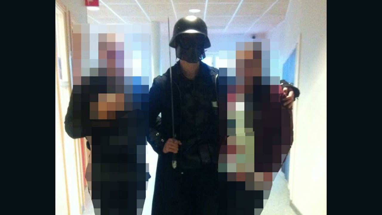 This picture, made available to AFP by a student, shows a masked man armed with a sword posing for a photo with two other students before attacking students and staff at the primary and middle school in Trollhattan, Sweden on October 22, 2015. 