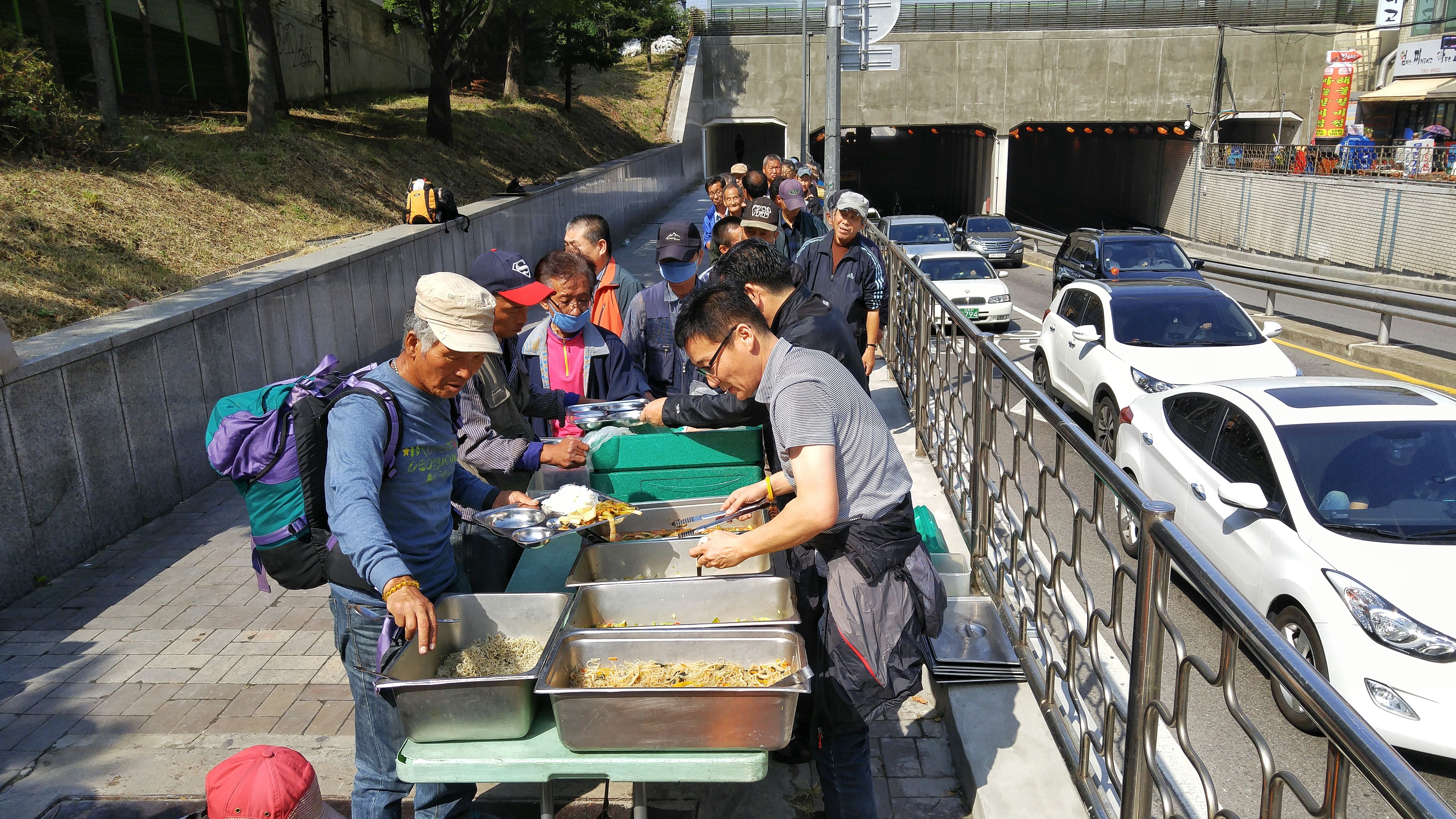 People line up to receive food from Pastor Choi Seong-Won's mobile soup kitchen.
