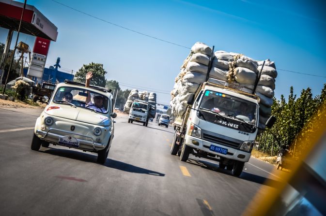 A Fiat 500 overtakes an overloaded truck.