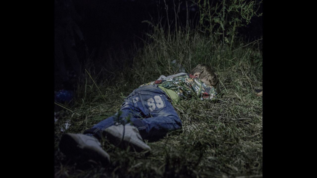 Ahmed, 6, sleeps on the ground in Horgos, Serbia. The adults were still sitting around after midnight, formulating plans for how they were going to get out of Hungary without registering themselves with the authorities. Ahmed carries his own bag over the long stretches that his family walks by foot. "He is brave and only cries sometimes in the evenings," says his uncle, who has taken care of him since his father was killed in their hometown in northern Syria.
