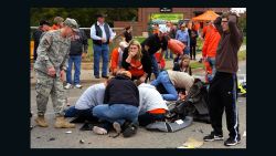 Bystanders help the injured after a vehicle crashed into a crowd of spectators during the Oklahoma State University homecoming parade, causing multiple injuries, on Saturday, Oct. 24, 2015 in Stillwater, Oka.  (David Bitton/The News Press via AP) MANDATORY CREDIT  