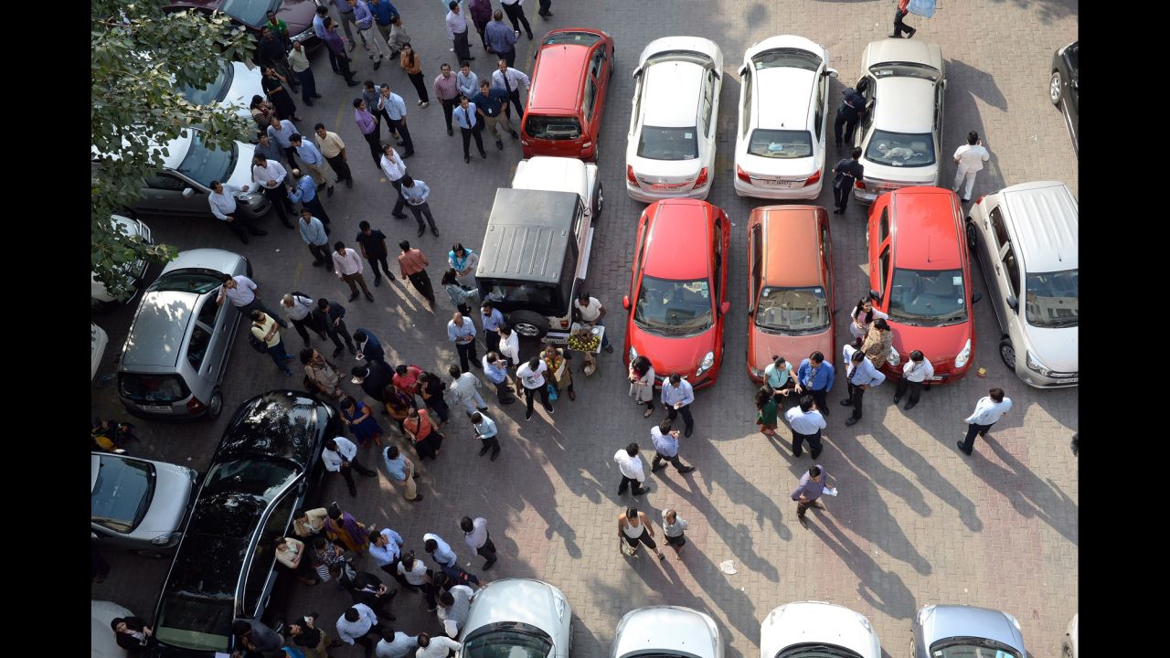 People stand in an open area in a parking lot in New Delhi after the quake.