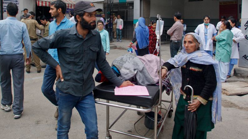 People wait after being shifted outdoors at the government medical college hospital in Jammu, India.