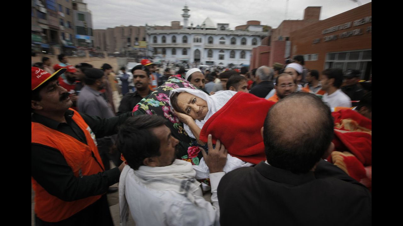 People rush an injured woman to a local hospital in Peshawar on October 26.