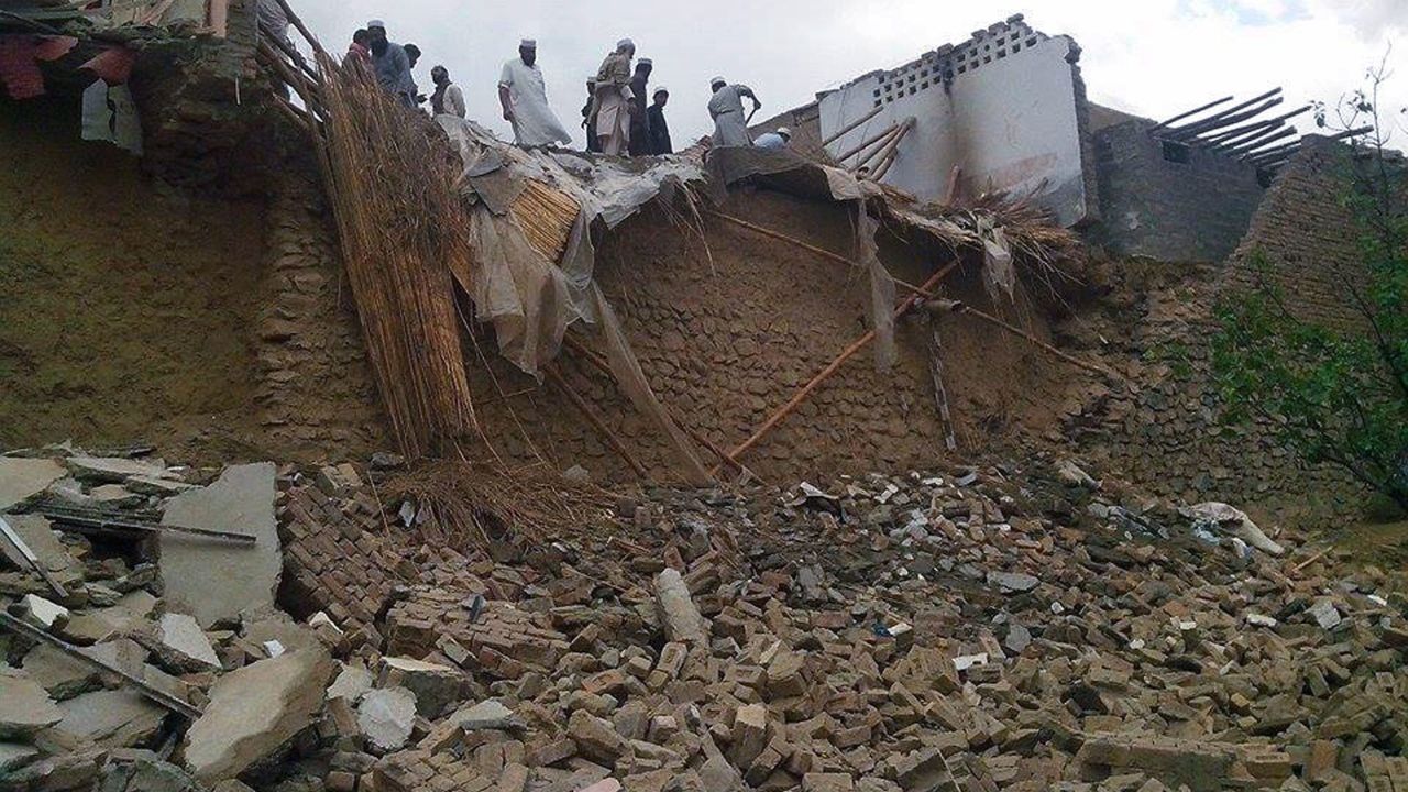 People look at collapsed houses in the Khyber Agency region of Pakistan.