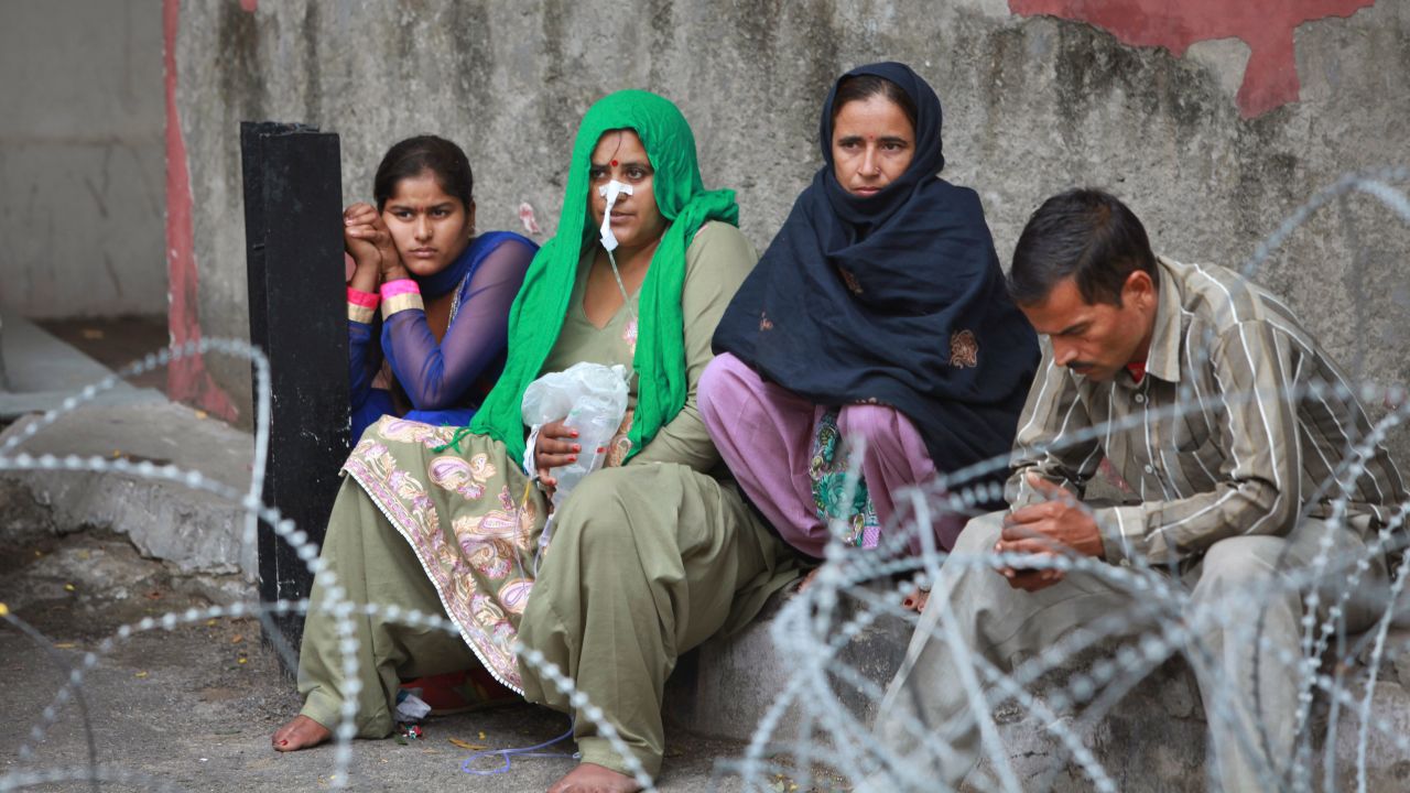 Patients sit outside the government medical college hospital after a strong tremor was felt in Jammu, India.