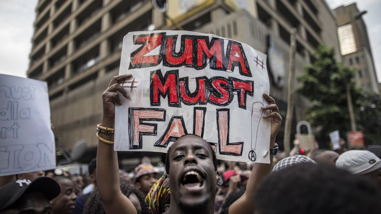 A student holds a placard reading 'A placard with "Zuma must fall" outside the Luthuli House, the ANC headquarters, on October 22, 2015, in Johannesburg, during a demonstration of thousands of students against university fee hikes.