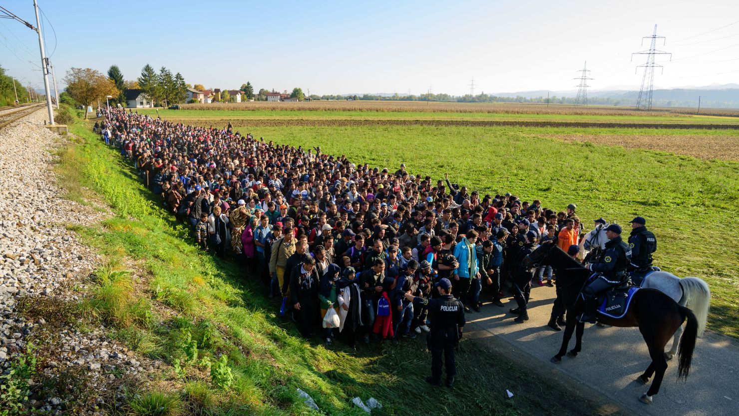 Police escort migrants toward a refugee center after crossing the Croatian-Slovenian border in 2015.