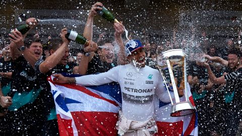 Lewis Hamilton of Great Britain and Mercedes GP celebrates with the team in the pit lane after winning the <a href="http://edition.cnn.com/2015/10/25/motorsport/motorsport-usgp-hamilton-vettel-rosberg/" target="_blank">United States Formula One Grand Prix</a> and the championship at Circuit of The Americas on Sunday, October 25, in Austin, Texas.  