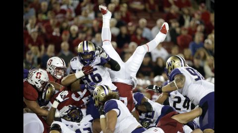 Stanford running back Remound Wright flips upside down as he leaps for a first down against the Washington Huskies during the first half of an NCAA college football game on Saturday, October 24, in Stanford, California.