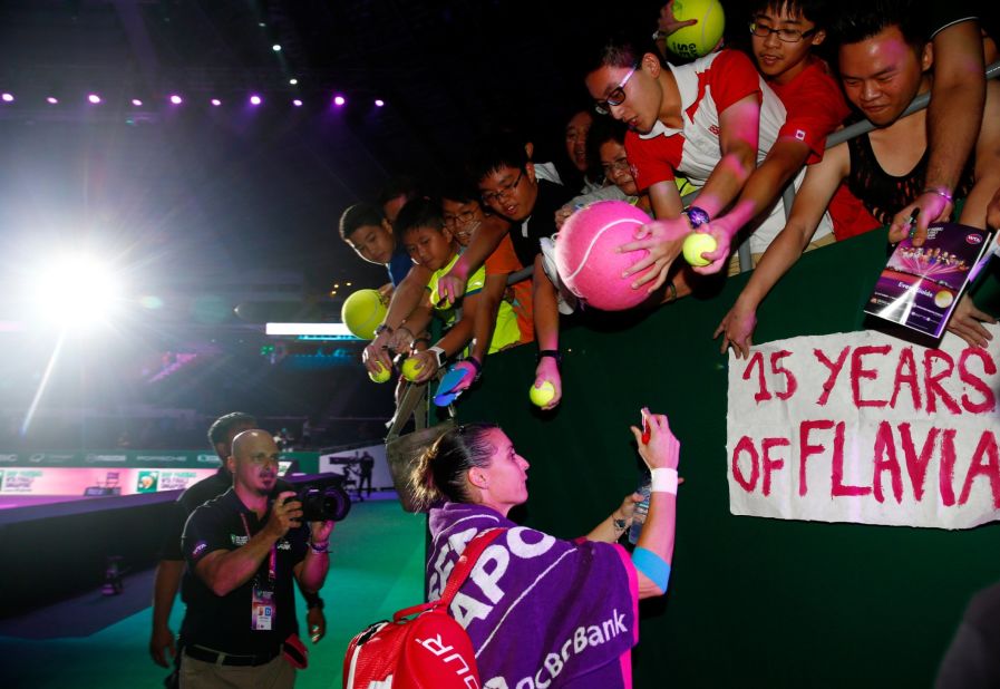 Pennetta signs autographs for fans after defeating Radwanska  7-6 (7-5) 6-4 in Tuesday's earlier Red Group match. Italy's U.S. Open champion kept her semifinal hopes alive ahead of her closing match against Sharapova. 