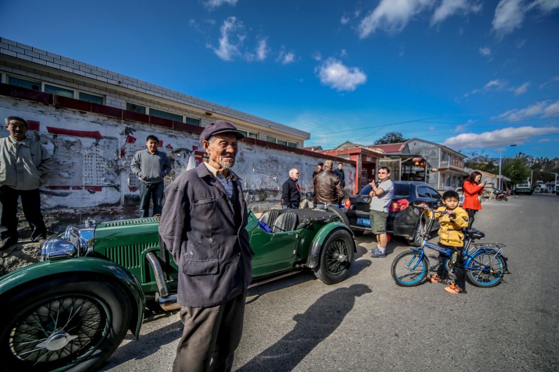 An Aston Martin Le Mans from 1933 is surrounded by curious locals.