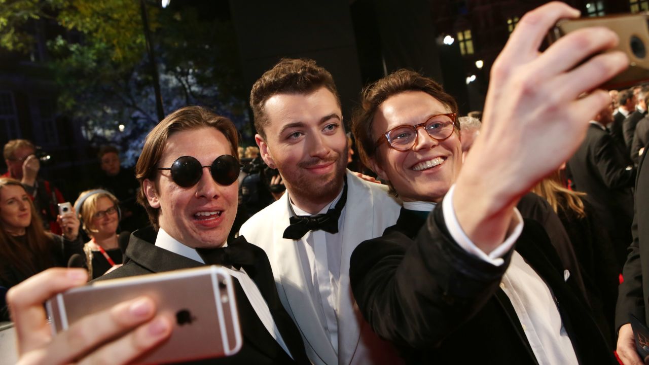 Singer Sam Smith, center, takes a selfie at the James Bond "Spectre" premiere in London on Monday, October 26. Smith recorded the film's theme song, "Writing's on the Wall."