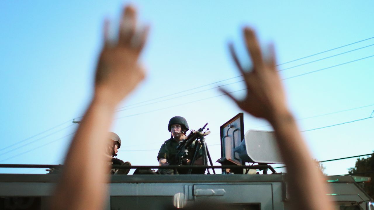 Police stand watch as demonstrators protest the shooting death of teenager Michael Brown on August 13, 2014 in Ferguson, Missouri. Brown was shot and killed by a Ferguson police officer on Saturday.