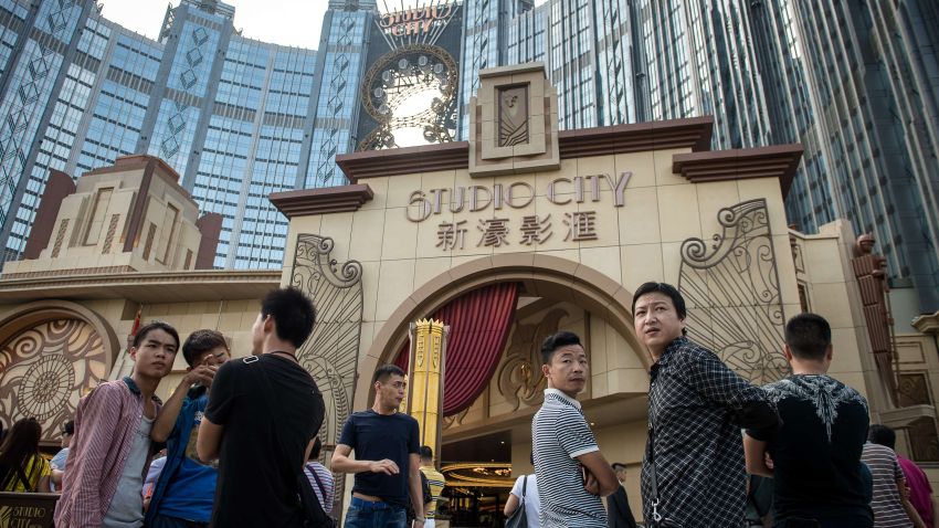 People stand outside the Studio City casino ahead of its opening in Macau on October 27, 2015. Casino operator Melco Crown was to open its latest resort Studio City as the city scrambles to diversify from gambling to the mass-market amid falling revenues.