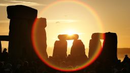 WILTSHIRE, UNITED KINGDOM - JUNE 21:  People watch the midsummer sun as it rises over the megalithic monument of Stonehenge on June 21, 2005 on Salisbury Plain, England. Crowds gathered at the ancient stone circle to celebrate the Summer Solstice; the longest day of the year in the Northern Hemisphere.  (Photo by Peter Macdiarmid/Getty Images)
