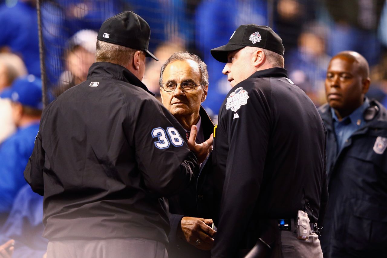 Joe Torre, Major League Baseball's chief baseball officer, meets with umpires in the fourth inning to discuss technical difficulties during Game 1.
