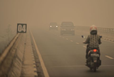 Commuters drive through thick haze in Tumbang Nusa, Central Kalimantan province, on October 25.
