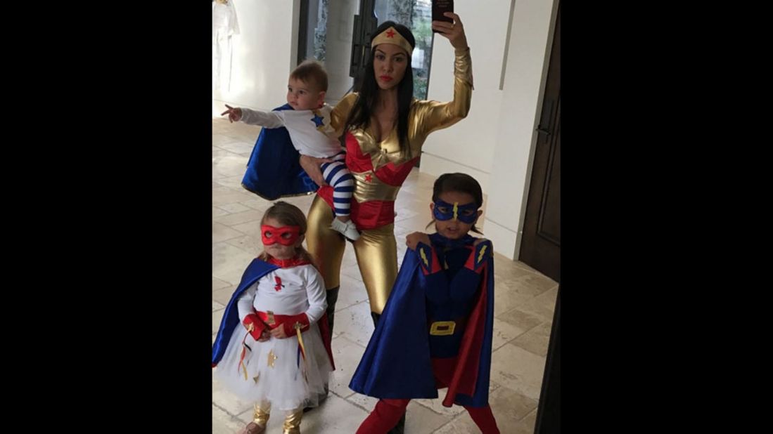 Kourtney Kardashian dressed as Wonder Woman in a red and gold jumpsuit while her three children were done up as mini-superheroes in this family selfie posted to Instagram on Saturday, October 24. 