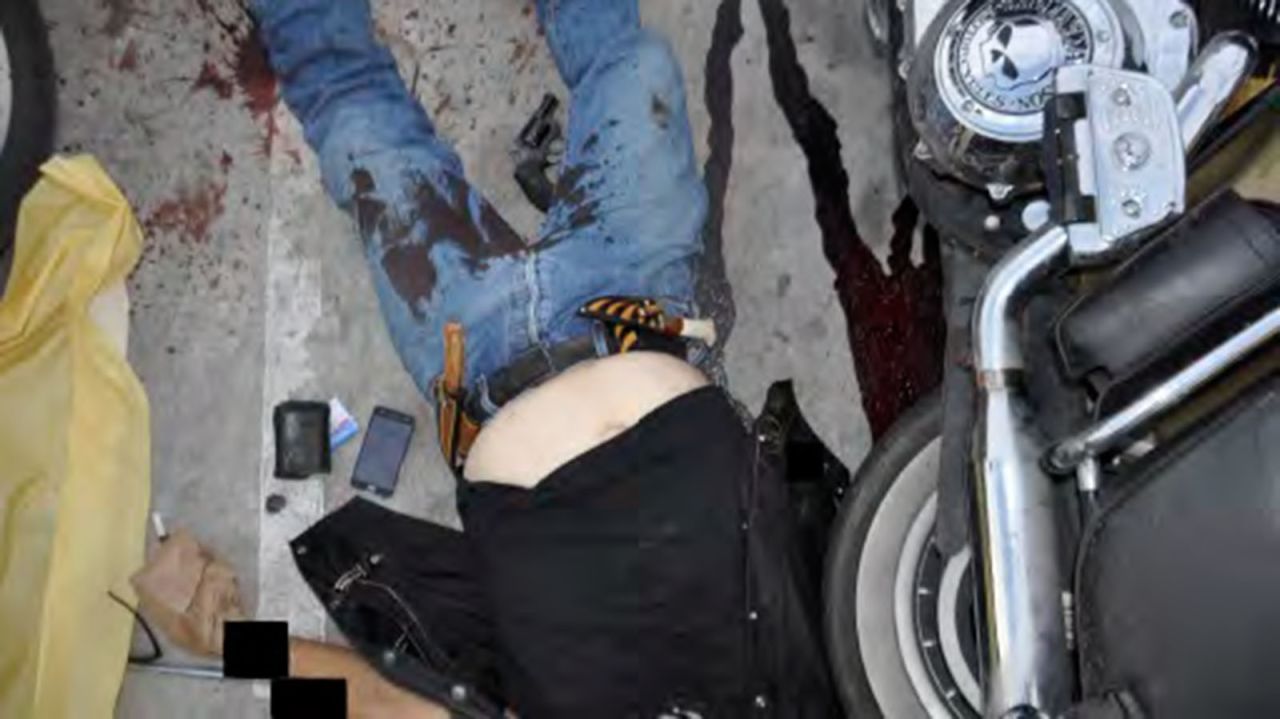 The body of a biker is seen in the parking lot. (His tattoos have been obscured in this photo.) The biker club members who began beating, stabbing and shooting each other in a Texas Twin Peaks restaurant knew the police were outside, and they just didn't care, Waco police Sgt. W. Patrick Swanton told CNN at the time.