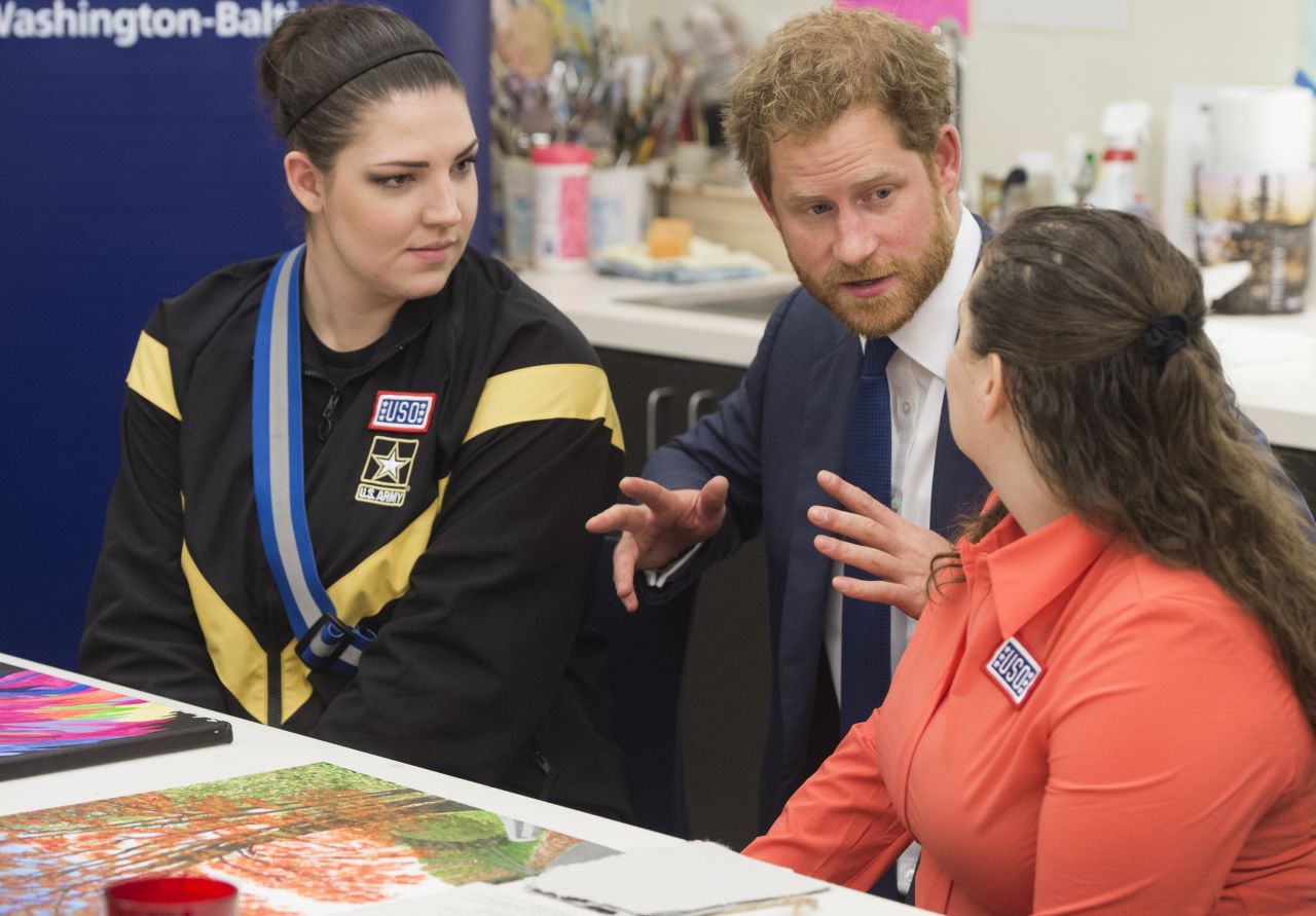 Prince Harry visits with wounded U.S. service members as he looks at their artwork during a tour of the center on October 28.