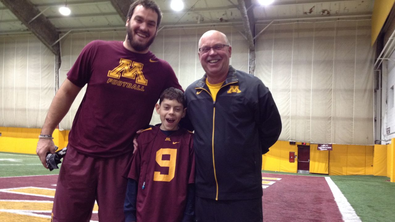The author's son, Billy Drash, suffers from epilepsy. Here, he poses with Minnesota football coach Jerry Kill and tight end Drew Goodger. The meeting was a turning point in the boy's care.