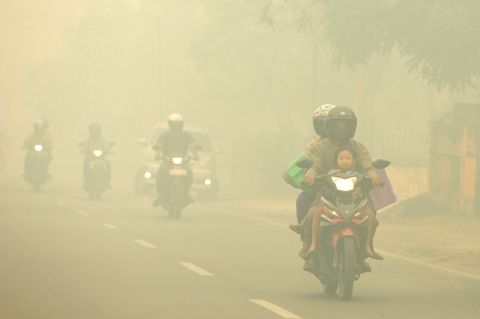 Motorists ride through thick haze choking the city of Palangkaraya, Indonesia, on October 27, 2015.