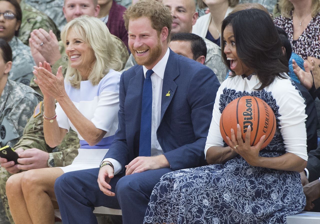 Obama reacts to catching a basketball alongside Harry and Biden at the October 28 game.