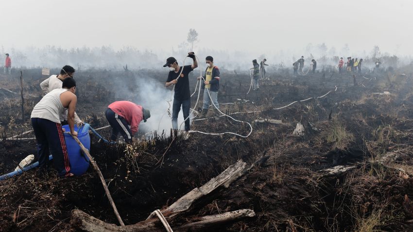 TO GO WITH Indonesia-environment-pollution,FOCUS by Dessy Sagita 
This photo taken on October 27, 2015 shows volunteers extinguishing a peatland fire in the outskirts of Palangkaraya, a city of 240,000 in Indonesia's central Kalimantan where respiratory illnesses have soared as the smog has worsened in recent weeks. Desperate civilians at the epicentre of Indonesia's haze crisis are taking the fight into the own hands, using whatever meager resources they have to confront the fires ravaging their communities as they tire of waiting for the government to take action.    AFP PHOTO / Bay ISMOYO        (Photo credit should read BAY ISMOYO/AFP/Getty Images)