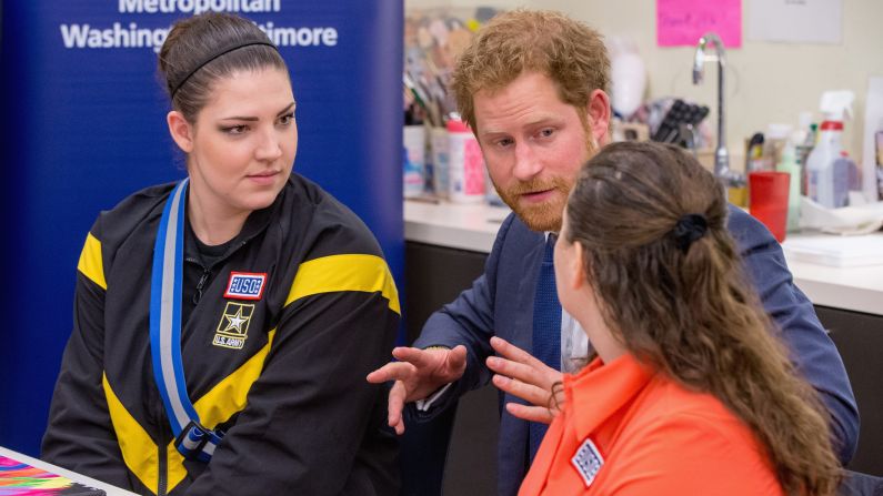 Prince Harry meets with servicewomen as he tours the USO Warrior and Family Center at the Fort Belvoir military base. 