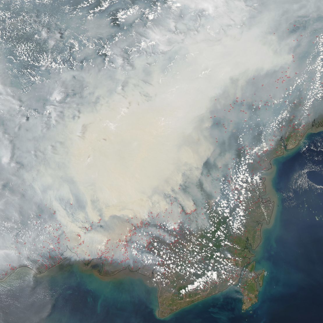 NASA's satellite captured this image of heavy smoke blanketing Borneo on October 19, 2015. The red outlines indicate areas where unusually warm surface temperatures associated with peat fires are detected.