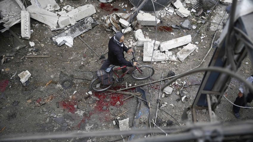 A Syrian man walks with a bicycle amid the rubble of destroyed buildings following a reported air strike by Syrian government forces in the rebel-held area of Douma, east of the capital Damascus, on October 29, 2015. AFP PHOTO / SAMEER AL-DOUMY        (Photo credit should read SAMEER AL-DOUMY/AFP/Getty Images)