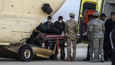 Egyptian paramedics load the bodies of victims into a military plane at a military air base by the Suez Canal on Saturday, October 31. 
