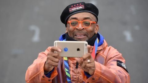 Movie director Spike Lee takes photos of the elite runners as they pass.