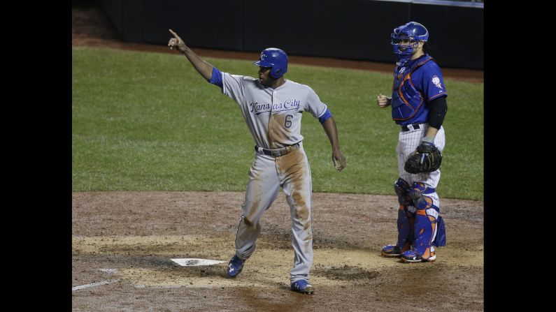 New York Mets catcher Travis d'Arnaud watches as Kansas City Royals' Lorenzo Cain signals to Eric Hosmer after Hosmer's RBI double during the ninth inning.