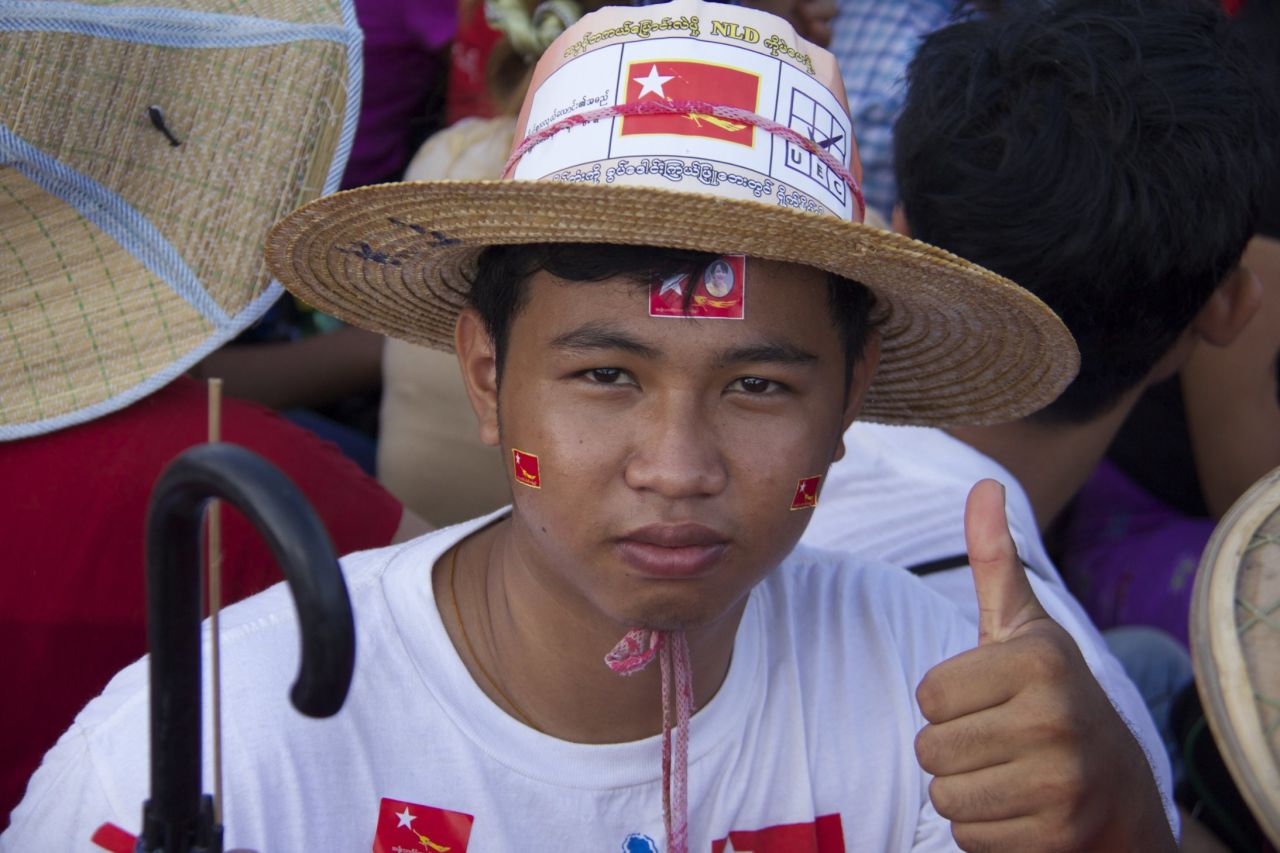 An NLD supporter dons accessories at the rally on November 1. The scene is festive because it's the first time in a generation party supporters get the chance to vote in national elections.
