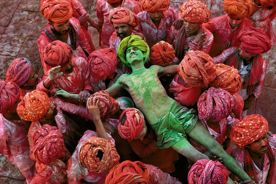 "McCurry has made many of these holy treks himself, and the rich tapestry of India's different faiths is one of the enduring themes of his work," continues Dalrymple.<br /><br />"There are beautiful images of devotees immersing statues of Ganesh in the sea at Mumbai, or playing Holi, the festival of colors, in Rajasthan, or visiting astrologers on the ghats of Varanasi."<br /><br />This luminously-colored photograph shows the crowd carrying a man during the Holi Festival in Rajasthan, in 1996.