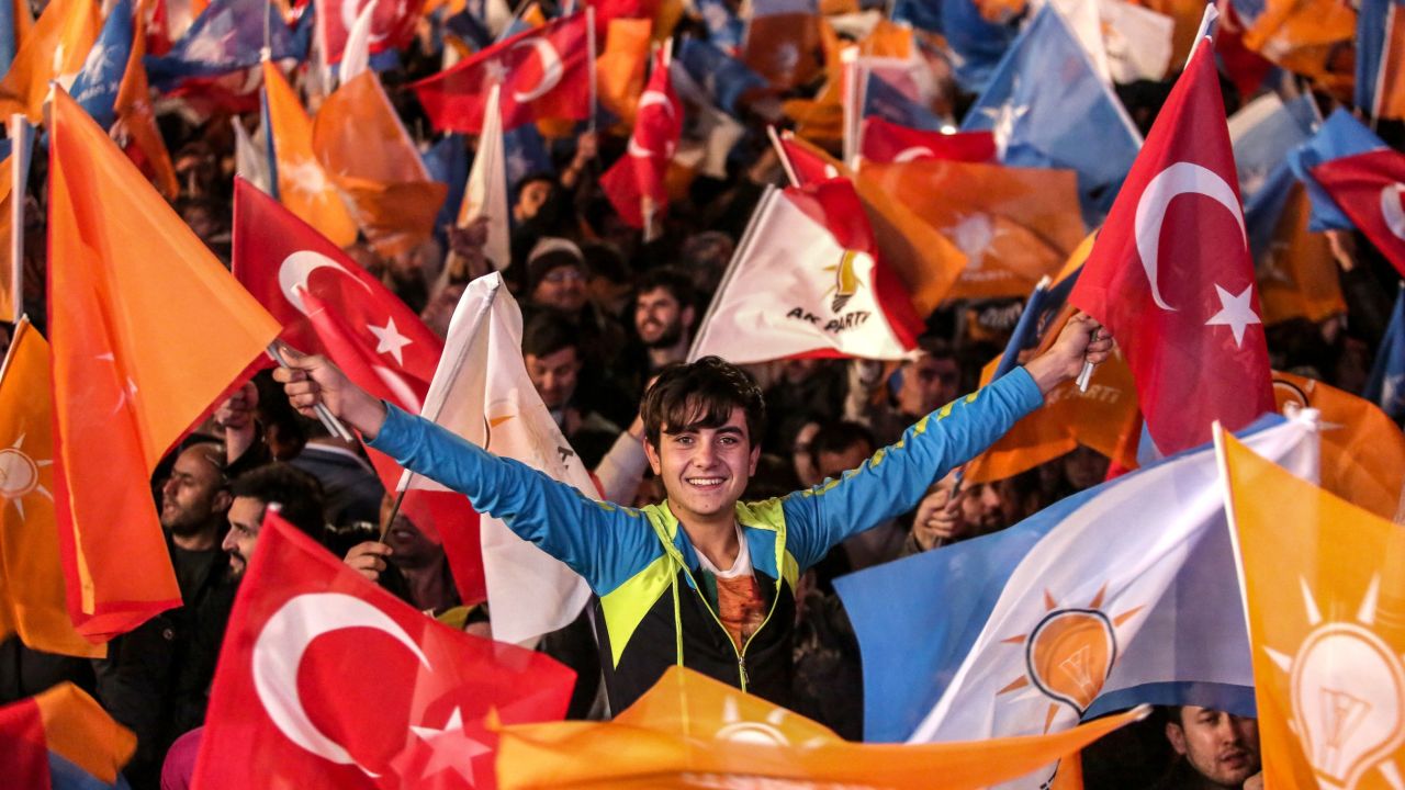 ANKARA, TURKEY - NOVEMBER 01:  People wave flags outside the ruling AK Party headquarters on November 1, 2015, in Ankara, Turkey. Polls have opened in Turkey's second general election this year, with the ruling Justice and Development Party (AKP) hoping to win a majority, as the country searches for stability amongst serious security concerns. (Photo by Burak Kara/Getty Images)