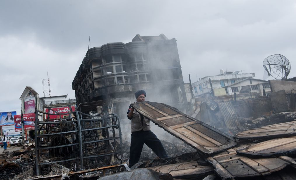 A fireman begins to clean up a burnt down market after riots broke out in Lashio in eastern Myanmar's Shan state on May 30, 2013. Security forces patrolled the riot-scarred streets of the town in eastern Myanmar after a fresh outbreak of religious violence that left one dead and several wounded. One person was killed and five injured in fighting between Muslims and Buddhists that saw a mosque and orphanage torched and stick-wielding mobs roaming the streets threatening Muslims. 