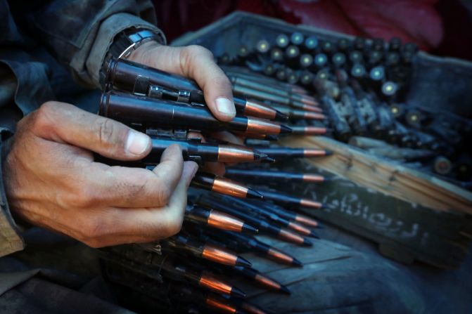 An Iraqi Kurdish Peshmerga fighter prepares an ammunition belt as he guards a position at the frontline of fighting against ISIS militants near the northern Iraqi town of Sinjar. 