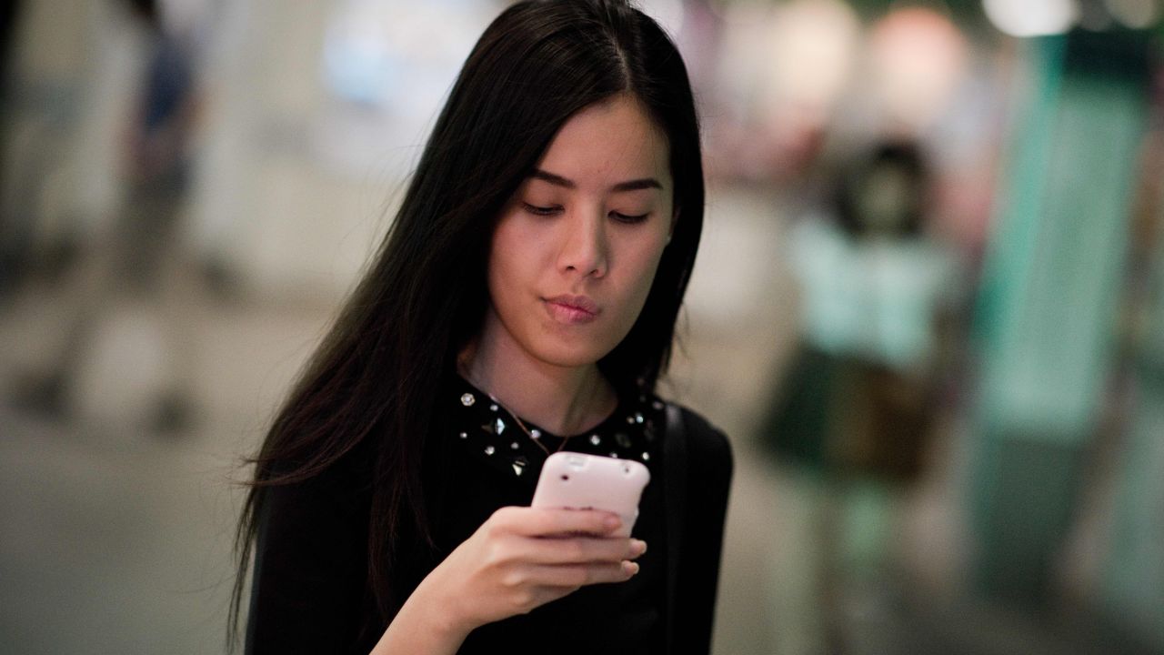 This picture taken on March 19, 2013 shows a woman looking at her smartphone while walking at a BTS train station in Bangkok. A recent Facebook-sponsored study showed smartphone owners are often connected all day. People can be found glued to their smartphones at airports, on trains, in restaurants and even while walking on the street, creating a disconnection from their immediate surroundings. Smartphone sales are expected to continue to surge in 2013 with some 918 million units to be bought worldwide. AFP PHOTO/ Nicolas ASFOURI (Photo credit should read NICOLAS ASFOURI/AFP/Getty Images)