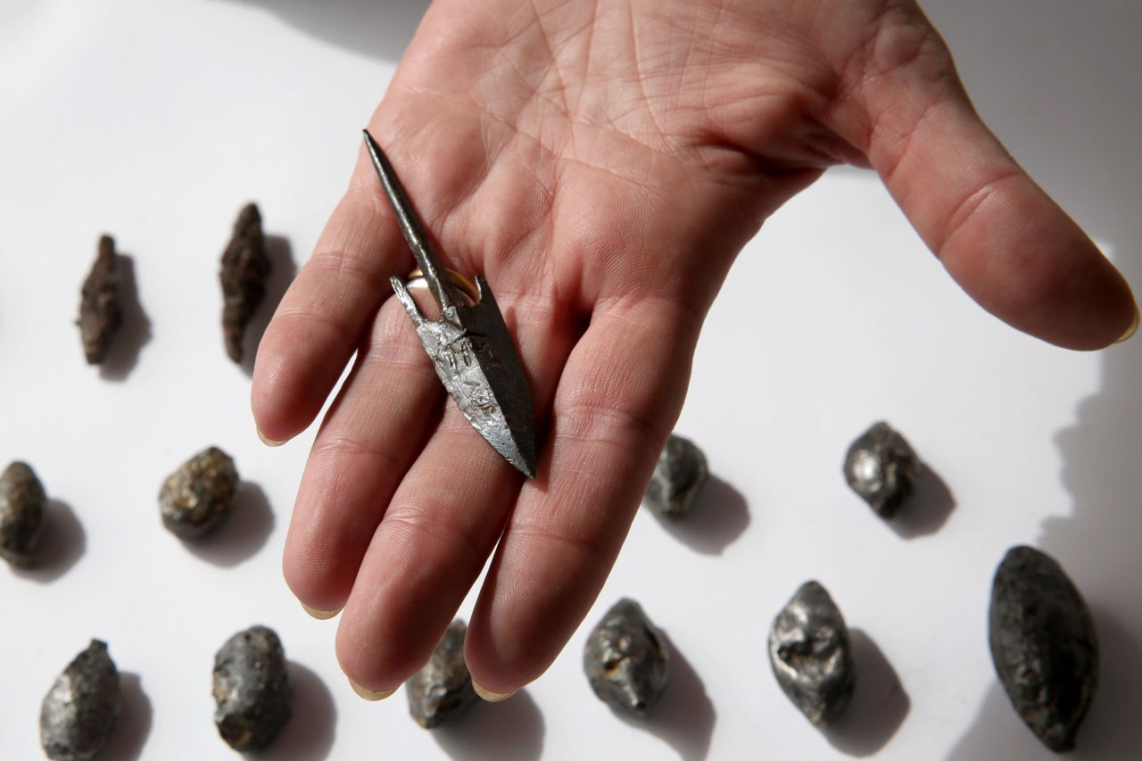 A member of the Israeli Antiquity Authority shows lead sling stones, bronze arrowheads, and ballista stones found at the excavation site on November 3. 