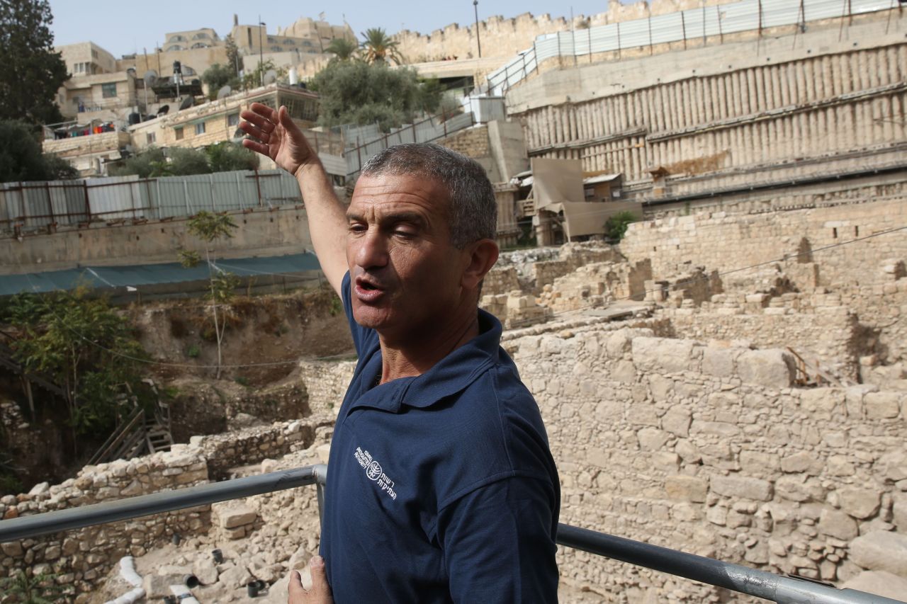 Doron Ben-Ami, an archaeologist from the Israeli Antiquities Authority, points at the excavation site on November 3. The more than 2,000-year-old fortress was unearthed from under a parking lot, solving a mystery archeologists have puzzled over for more than a century. 